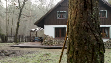 Schönes-Süßes-Weißes-Mit-Braunem-Ferienhaus-Im-Wald-In-Der-Nähe-Von-Bartoszylas-In-Polen-An-Einem-Nebligen-Morgen