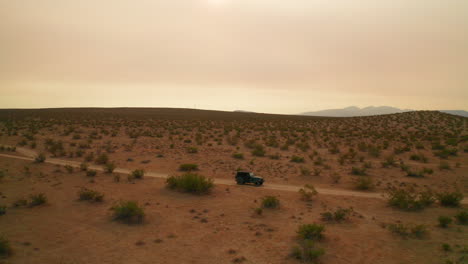 Jeep-Estacionado-En-El-Paisaje-Solitario-Y-Duro-Del-Desierto-De-Mojave---Vista-Aérea
