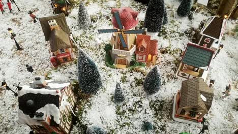 Picturesque-snowy-Christmas-model-toy-town-aerial-view-above-scenic-display