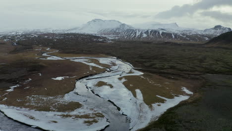 S-curve-River-Flowing-By-Icelandic-Fields-With-Snaefellsjokull-Volcano-In-Background-In-Snaefellsjokull,-Western-Iceland