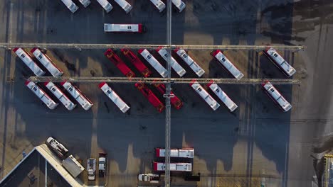 TTC-public-transit-buses-at-large-operations,-maintenance-and-storage-facility-top-down-as-bus-drives-through-parking-lot