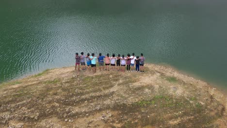 Group-Of-Happy-Friends-Embracing-While-Standing-On-Lake-Shore-At-Danao-Lake-Natural-Park-In-Leyte,-Philippines