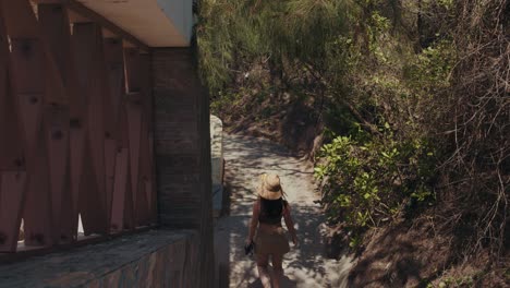 Girl-in-a-hat-walking-down-the-stairs-of-a-tropical-hotel-resort