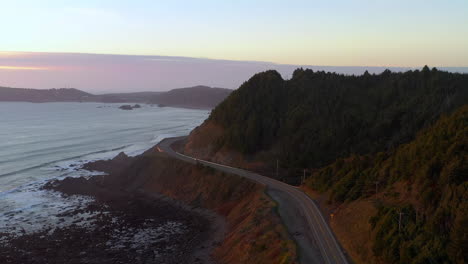 Car-driving-on-scenic-road-101-at-sunset-near-Port-Orford,-Oregon