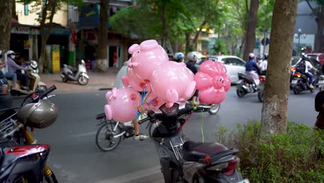 Toma-En-Cámara-Lenta,-Globos-Rosas-Atados-A-La-Moto,-Tráfico-De-Hora-Punta-En-El-Fondo,-Vietnam