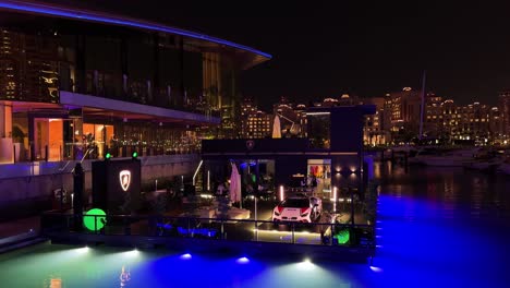luxury-car-show-room-boutique-on-the-sea-water-in-pearl-lulu-Qatar-Lamborghini-sport-car-at-night-in-Venice-like-qanat-quartier-mushroom-building-architectural-design-blue-light-dark-café-lounge