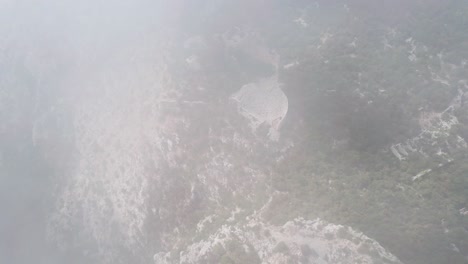 Cloudy-mountains-aerial-drone-shot-showing-ancient-greek-amphitheatre-Termessos,-Antalya,-Turkey