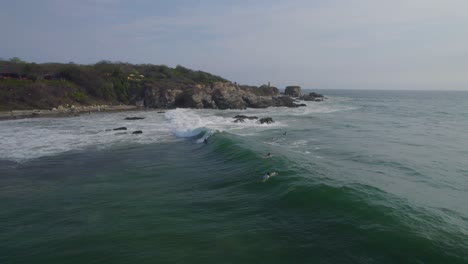 Aerial-view-of-surfers-trying-to-catch-the-next-big-wave-in-Mexico