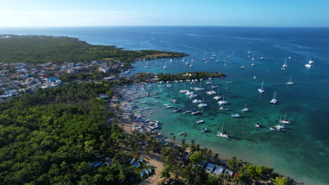 Aerial-view-of-a-coast-with-a-stunning-beach-with-boats-a-vegetation,-touristic-place