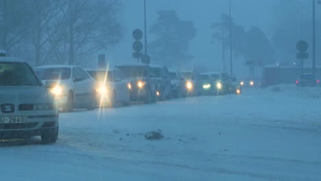 Busy-Neste-petrol-station-with-queues-of-people-refilling-their-cars-in-fear-of-fuel-shortages,-rising-prices,-hype-at-gas-stations,-overcast-winter-day-with-heavy-snowstorm,-medium-handheld-shot