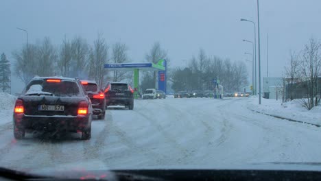 Concurrida-Gasolinera-Neste-Con-Colas-De-Personas-Que-Rellenan-Sus-Coches-Por-Miedo-A-La-Escasez-De-Combustible,-Aumento-De-Los-Precios,-Exageración-En-Las-Gasolineras,-Día-De-Invierno-Nublado-Con-Fuerte-Tormenta-De-Nieve,-Amplio-Tiro-De-Mano