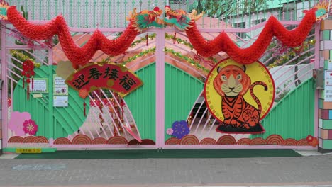 Fußgänger-Gehen-An-Einem-Kindergarten-Vorbei,-Der-Vor-Dem-Bevorstehenden-Chinesischen-Neujahrsfest-In-Hongkong-Mit-Chinesischen-Neujahrsornamenten-Geschmückt-Ist