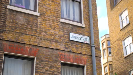 John-Street-Sign-En-La-Pared-Exterior-De-Ladrillo-De-Un-Edificio-En-Londres,-Reino-Unido