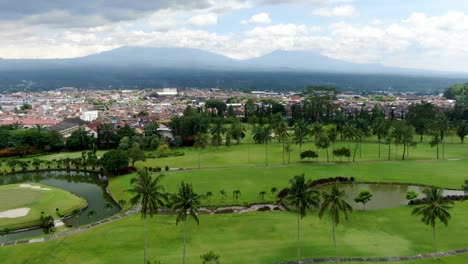 Mount-Merapi-and-Merbabu-behind-city-of-Yogyakarta,-aerial-fly-forward-view