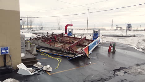 Drone-view-of-roof-on-gas-station-torn-off-in-extreme-winter-storm---Dolly-Shot