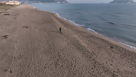Mujer-Y-Perro-Salchicha-En-Miniatura-Corriendo-Por-La-Playa-Vacía