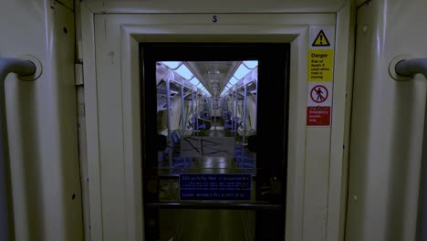 Blick-Durch-Die-Tür,-Die-Mit-Einem-Anderen-Leeren-Waggon-Auf-Dem-Zug-Der-Jubilee-Line-In-London-Verbunden-Ist