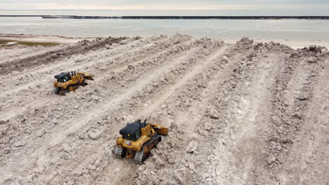 Aerial-of-bulldozers-moving-heaps-of-snow-after-winter-storm,-Buffalo
