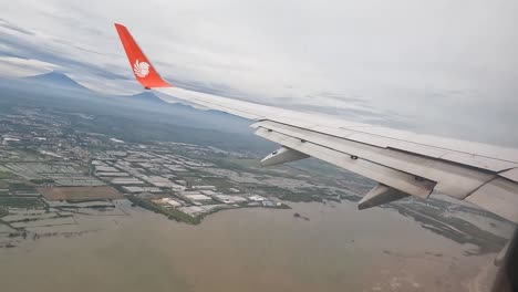 Flooded-landscape-of-Indonesia-and-small-town,-view-from-plane