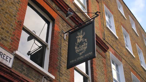 Lady-Ottoline-Pub-Schild-An-Einer-Hängenden-Klammer-An-Der-Außenfassade-In-London,-England,-Niedriger-Winkel