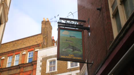 The-Dolphin-Tavern-Sign-Hanging-On-Exterior-Front-Wall-Of-Building-In-London,-UK