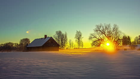 Timelapse-View-Of-Golden-Sun-Rising-On-Horizon-Over-Lone-Wooden-Barn-On-Snow-Covered-Landscape