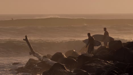 Surfers-waiting-to-enter-the-water-at-sunrise-at-Burleigh-Heads-on-the-Gold-Coast,-Australia