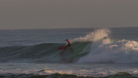 Surfers-catching-waves-at-sunrise-at-Burleigh-Heads-on-the-Gold-Coast,-Australia