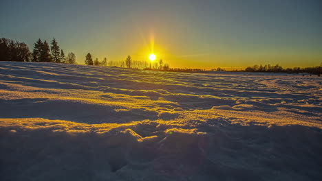 Zeitraffer-Des-Goldenen-Sonnenuntergangs-über-Einem-Winterwunderland---Niedriger-Winkel-Betont-Die-Bewegung,-Die-Schatten-Und-Die-Reflexion-Auf-Dem-Schnee