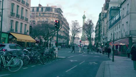 Pariser-Straßen-Mit-Vielen-Flanierenden-Menschen,-Im-Hintergrund-Die-Julisäule-Auf-Dem-Place-De-La-Bastille,-Wintersaison