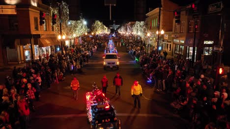 Christmas-Parade,-Celebration-of-Santa-Claus-Parade-by-Night-Along-Street-in-Denver,-Floats-Marching-Bands-and-People-Crowd-on-Both-Sides-of-The-Street