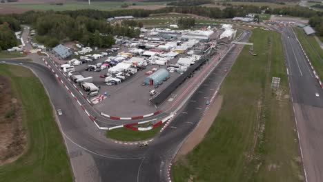 Amplia-Toma-Aérea-En-órbita-Que-Muestra-Autos-De-Carrera-En-La-Pista-De-Carreras-En-Suecia