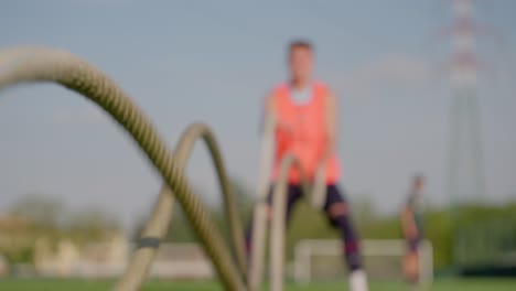 Slow-motion-shot-of-out-of-focus-soccer-player-performing-rope-training