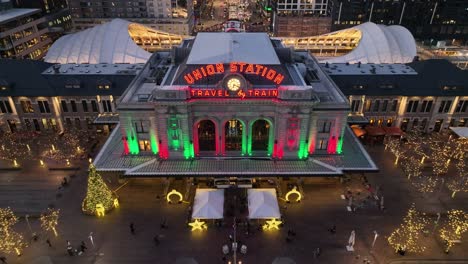 Vista-Al-Aire-Libre-De-La-Estación-De-Tren-De-Denver-Union-Al-Atardecer-Iluminada-Durante-La-Navidad,-Vista-Aérea-De-Luces-Coloridas-En-El-Distrito-Del-Centro