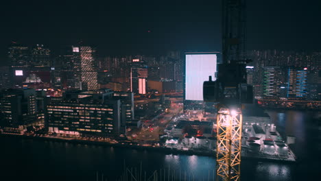 Umkreisende-Aufschlussreiche-Drohne,-Die-Um-Einen-Baukran-Geschossen-Wurde,-Mit-Dichten-Gebäuden-In-Der-Kowloon-Bay-Im-Hintergrund
