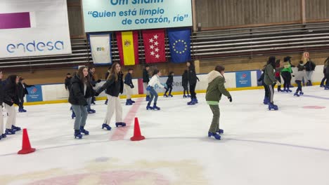 Vista-Panorámica-Derecha-Que-Revela-A-Muchas-Personas-Patinando-Sobre-Hielo-En-Una-Pista-De-Hielo-Cubierta-En-España