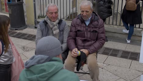 Two-men-in-Matera,-Italy-with-character-drawings-laughing