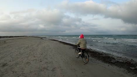 Biker-Frau,-Die-Bei-Sonnenuntergang-In-Zeitlupe-Fahrrad-Durch-Den-Strand-Fährt