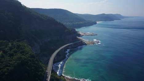 Epic-driving-bridge-on-ocean-Australia-SeaCliff-Bridge-Summer-Backward-Drone-Stunning-summer-day-drone-cinematic-by-Taylor-Brant-Film