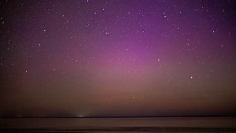 Time-lapse-shot-of-purple-sky-with-moving-stars-and-flashing-lights-during-aurora-borealis-at-night