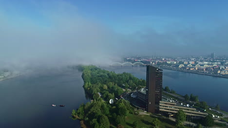 Edificio-De-Televisión-De-Letonia-En-La-Isla-De-La-Ciudad-De-Riga,-Vista-Aérea-Del-Día-De-Niebla