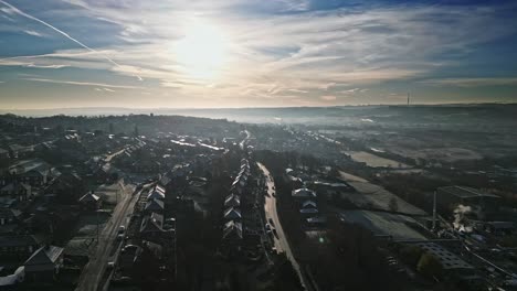 Harsh-cold-winter-aerial-footage-of-a-town-city-landscape,-with-low-afternoon-lighting-and-freezing-sunlit-houses