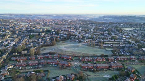 Aerial-footage-of-a-mist-covered-urban-town-of-Dewsbury-Moor-Council-Estate-in-Yorkshire-UK,-showing-busy-roads-traffic-and-red-brick-houses