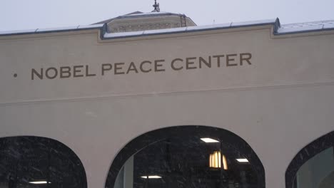 Close-Up-View-Of-The-Nobels-Fredssenter-Sign-On-Wall-With-Snow-Falling