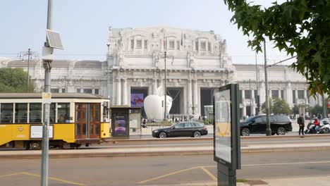 Main-train-station-of-Milan-exterior-with-street-traffic-in-foreground,-handheld