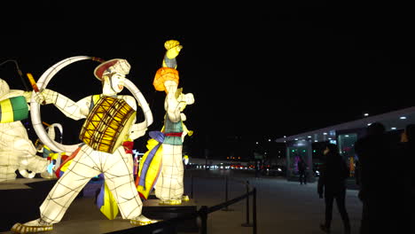 People-Passing-By-Illuminated-Displays-At-The-Gwanghwamun-Square-At-Night