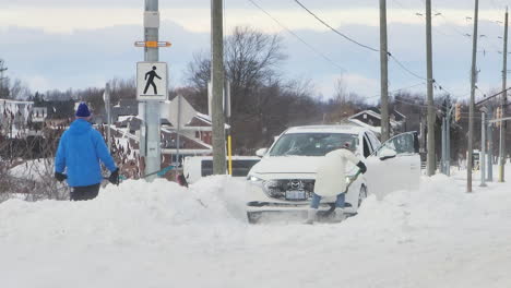 Residents-Shoveling-Snow-Off-The-Street-To-Clear-Path-For-Vehicle-During-Winter-Storm-In-Fort-Erie,-Ontario,-Canada