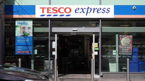 Männer-Unterschiedlicher-Herkunft-Gehen-Im-Tesco-Express-Shop-In-Canary-Wharf,-London,-Ein-Und-Aus