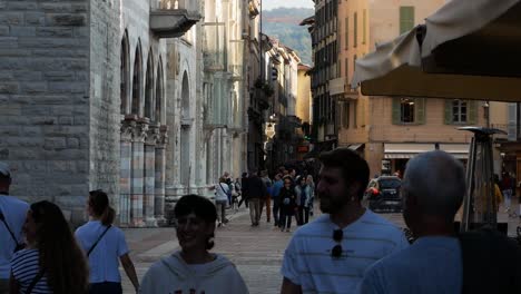 Central-square-of-Como-and-people-walking-by,-handheld-view