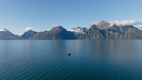 Idyllische-Norwegische-Landschaft-Am-Sommertag-Mit-Fischerboot-über-Lyngenfjordwasser-Und-Bergen-Der-Skandinavischen-Alpen-Im-Hintergrund,-Norwegen